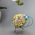 Load image into Gallery viewer, Golden Crown Easter Egg Beaded Ornament embellished with flowers, gold leaves, floral trim, and crystal beads. Top detail. (Light Yellow).