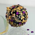 Load image into Gallery viewer, Quam Handmade Christmas Satin Ornament in Black with gold metal embellishments and purple rhinestones in front of evergreen branch. (Black)