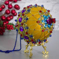 Load image into Gallery viewer, Close-up of the Bottom of Scheherazade Handmade Satin Ornament -Festive mustard-colored ball with red beads, rhinestones, gold trim, sequins, indigo rhinestone chain. (Gold)