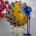 Load image into Gallery viewer, Close-up Detail of Scheherazade Handmade Satin Ornament -Festive mustard-colored ball with purple rhinestones, sparkling gold trim, sequins, indigo rhinestone chain, and metallic cord. (Gold)