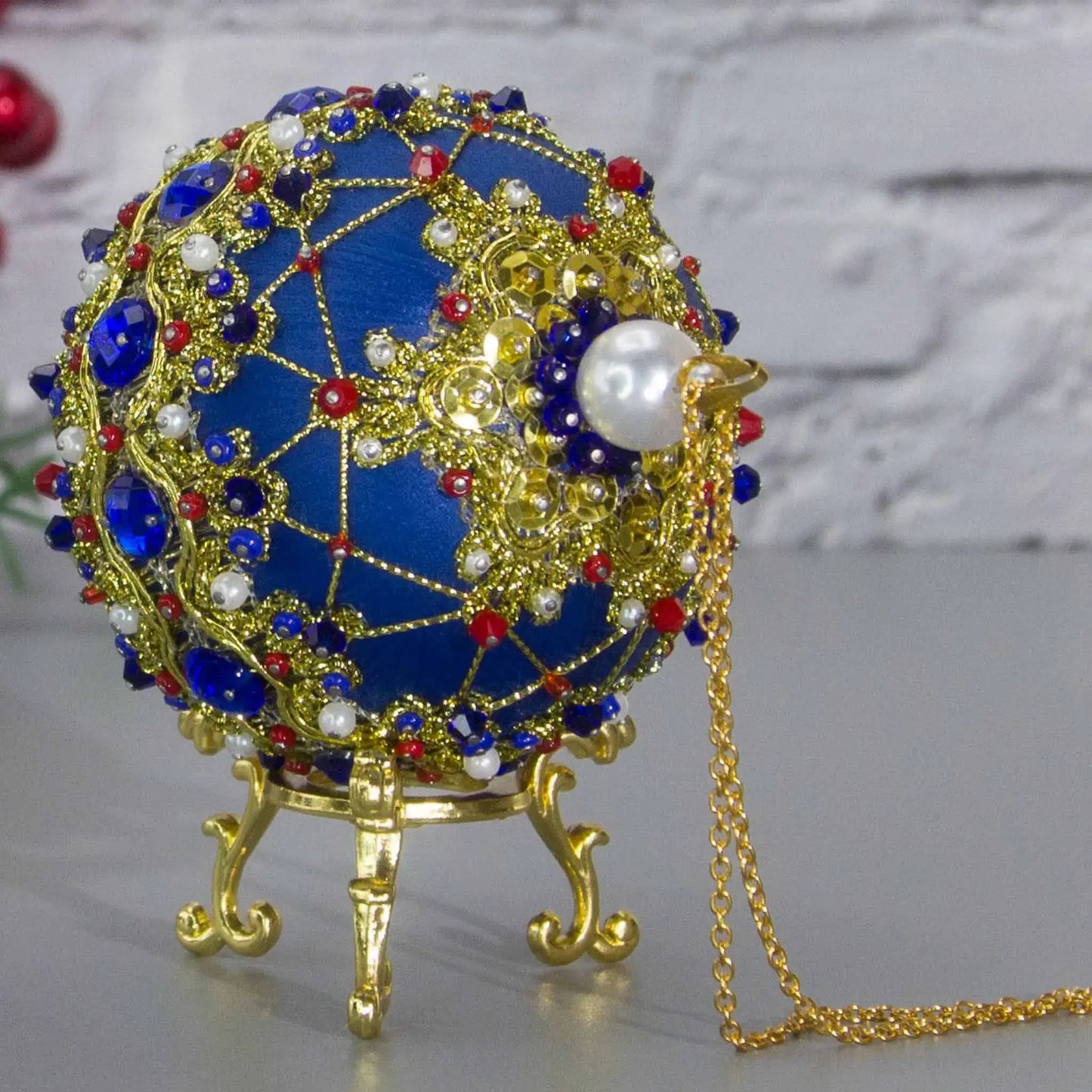 Scheherazade Handmade Satin Ornament -Top Close-Up Pearl Detail. Festive blue ball with indigo rhinestones, sparkling gold trim, sequins, red bicone beads, and metallic cord. (Dark Slate Blue)