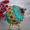 Load image into Gallery viewer, Close-up Detail of Scheherazade Handmade Satin Ornament - Teal -colored ball with red rhinestones, blue accents, sequins, seed beads, gold chain, and metallic cord. (Light Sea Green)