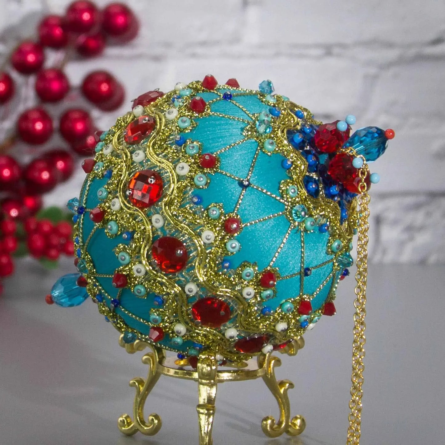 Close-up Detail of Scheherazade Handmade Satin Ornament - Teal -colored ball with red rhinestones, blue accents, sequins, seed beads, gold chain, and metallic cord. (Light Sea Green)