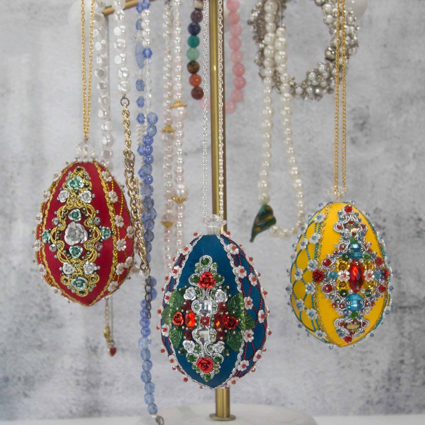 Collection of handmade satin ornaments embellished with crystals, beads, and metallic trim