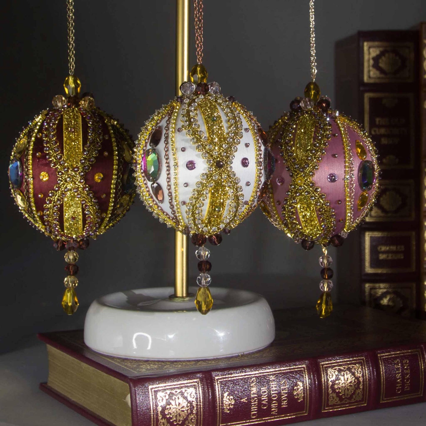 Collection of handmade Beaded Christmas Ornaments Uliger embellished with gold trim, color-shifting rhinestones, and sequins.