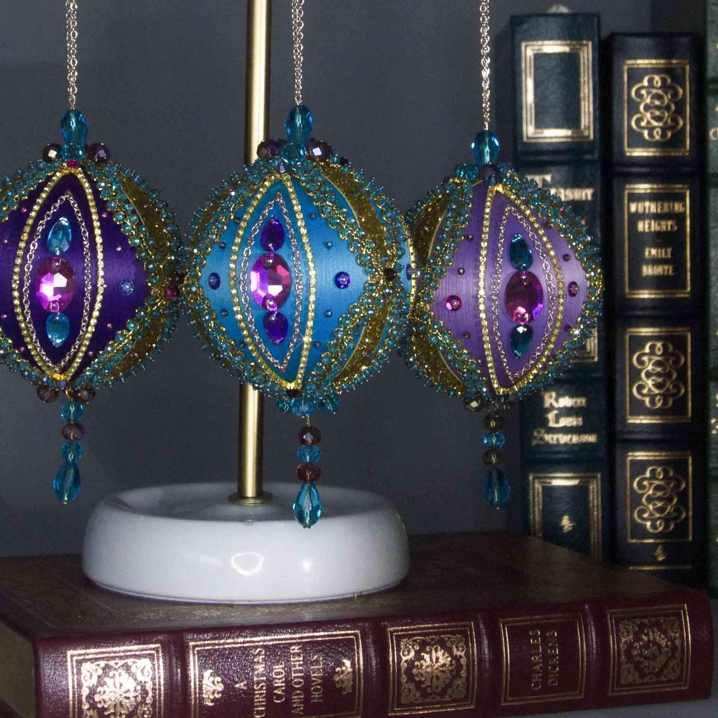 Collection of handmade Beaded Christmas Ornaments Uliger embellished with gold trim, color-shifting rhinestones, and sequins.