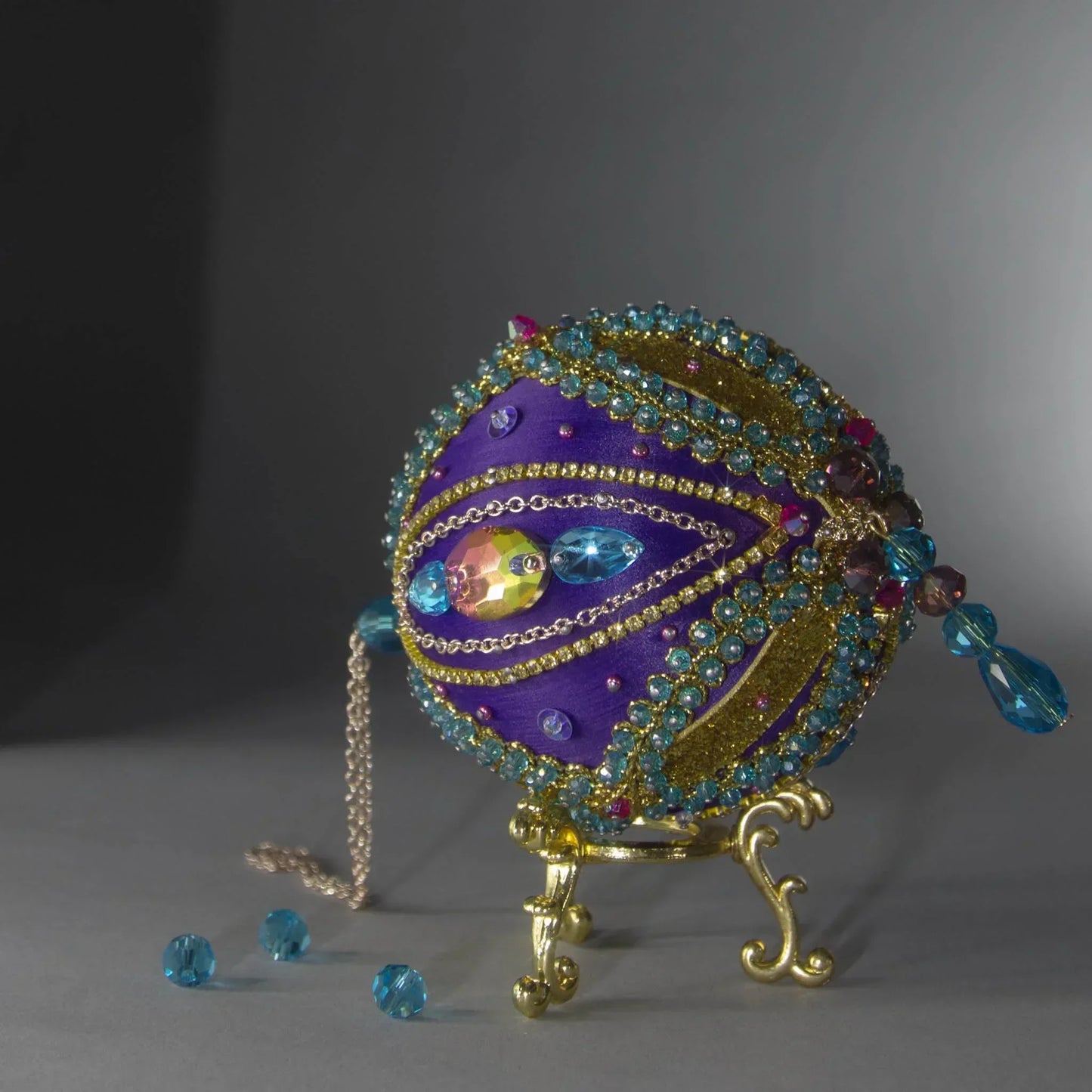 Christmas Beaded Ornament Kit Ball embellished with glass rhinestones, gold braided trim, and crystal beads. Bottom detail. (Indigo).