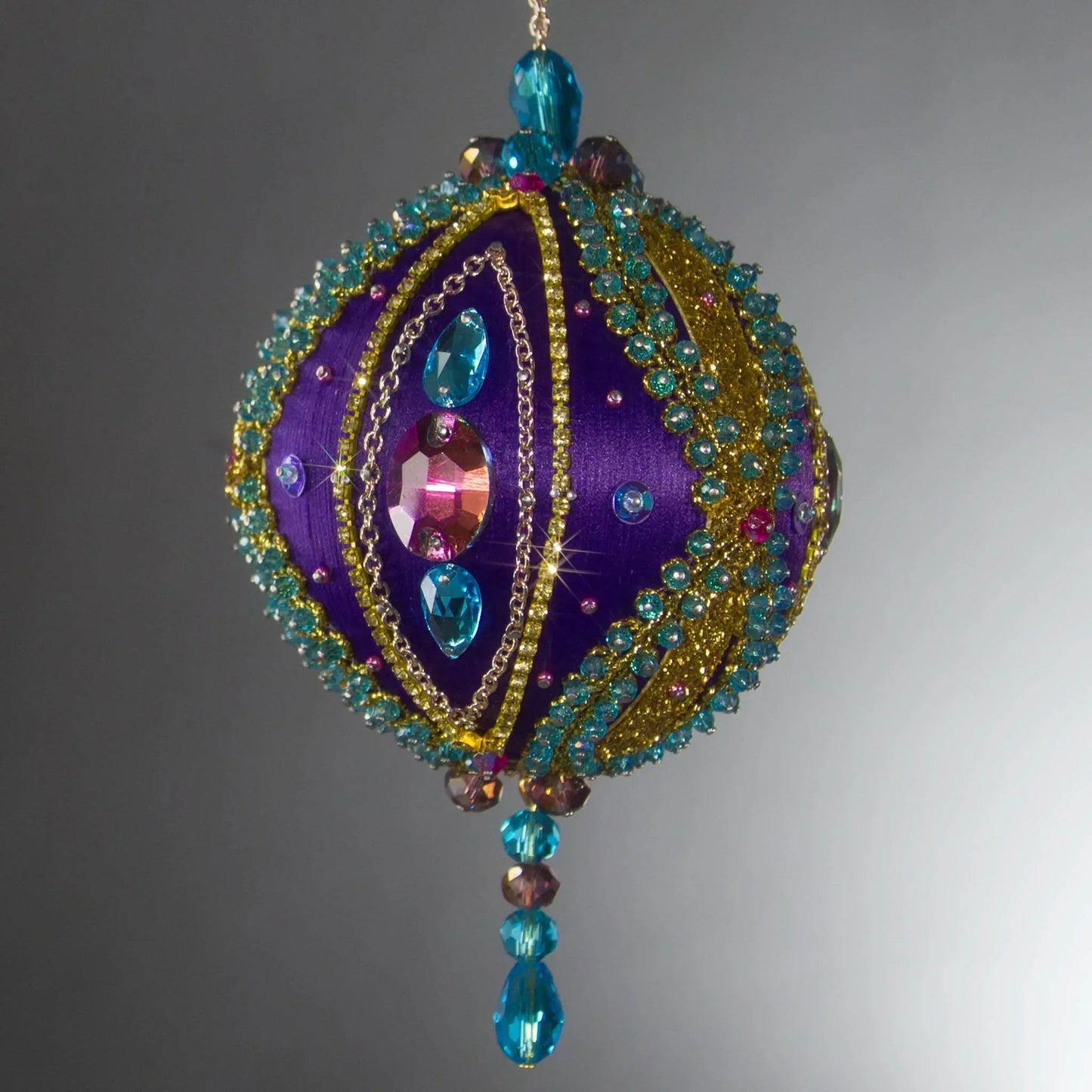 Christmas Beaded Ornament Kit Ball embellished with glass rhinestones, gold braided trim, and crystal beads. Front. (Indigo).