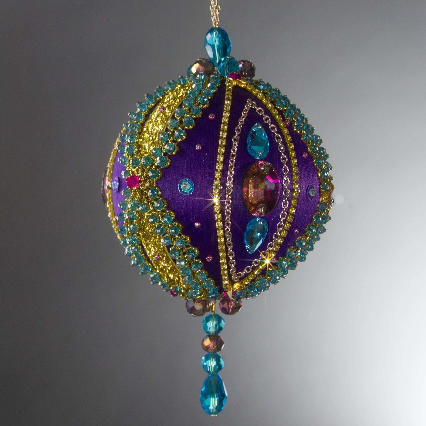 Christmas Beaded Ornament Kit Ball embellished with glass rhinestones, gold braided trim, and crystal beads. Side view. (Indigo).