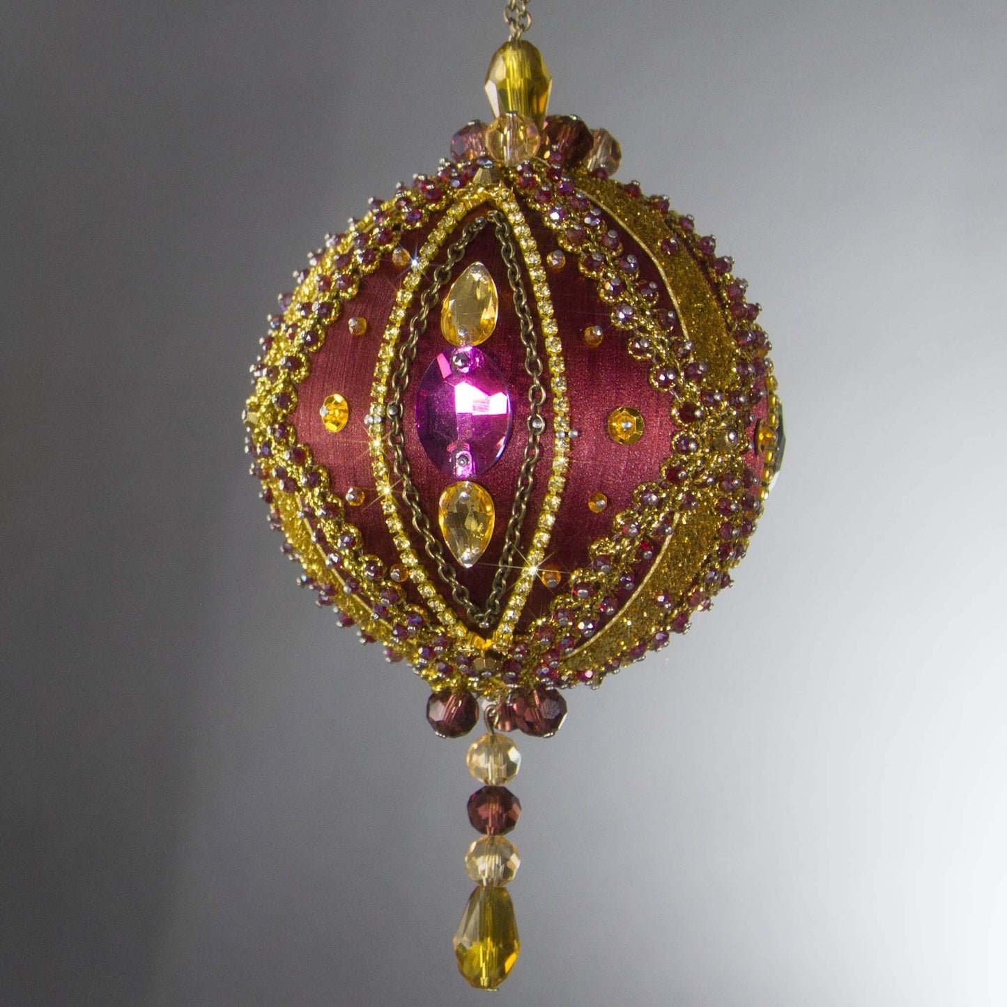 Handmade Satin Ornament by Whim5seasons, but also has a Kit to create a decoration embellished with glass rhinestones, gold braided trim, and crystal beads. Front. (Maroon).