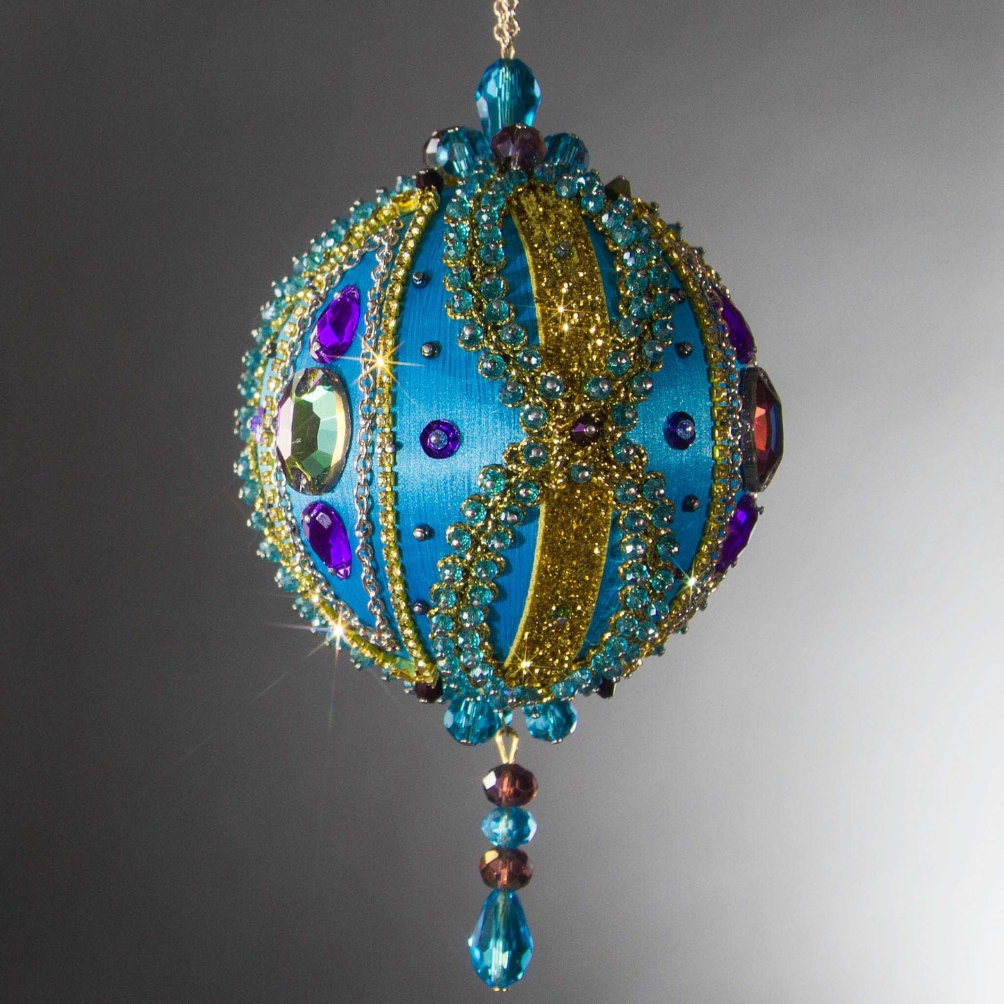 Christmas Beaded Ornament Kit Ball embellished with glass rhinestones, gold braided trim, and crystal beads. Front. (Sky Blue).