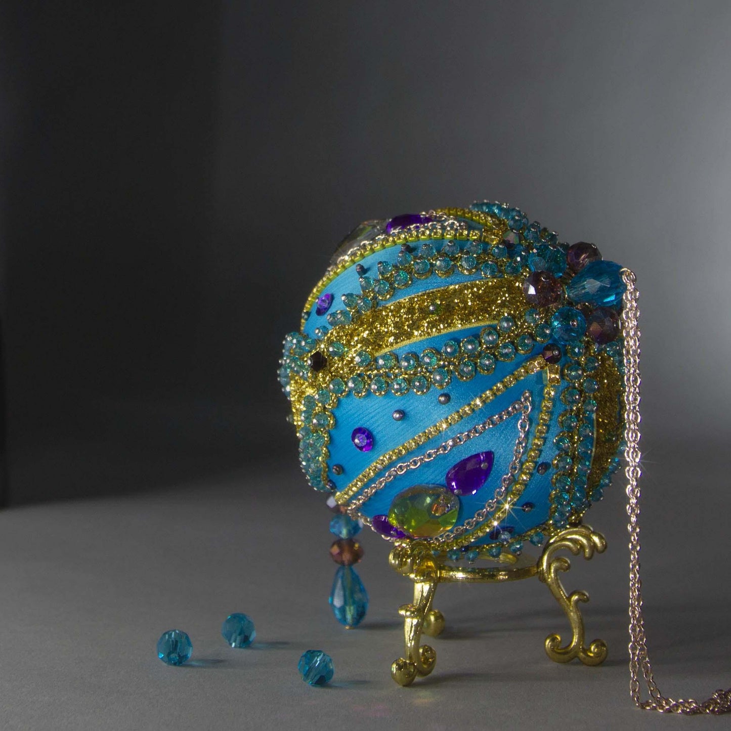 Christmas Beaded Ornament Kit Ball embellished with glass rhinestones, gold braided trim, and crystal beads. Top detail. (Sky Blue).