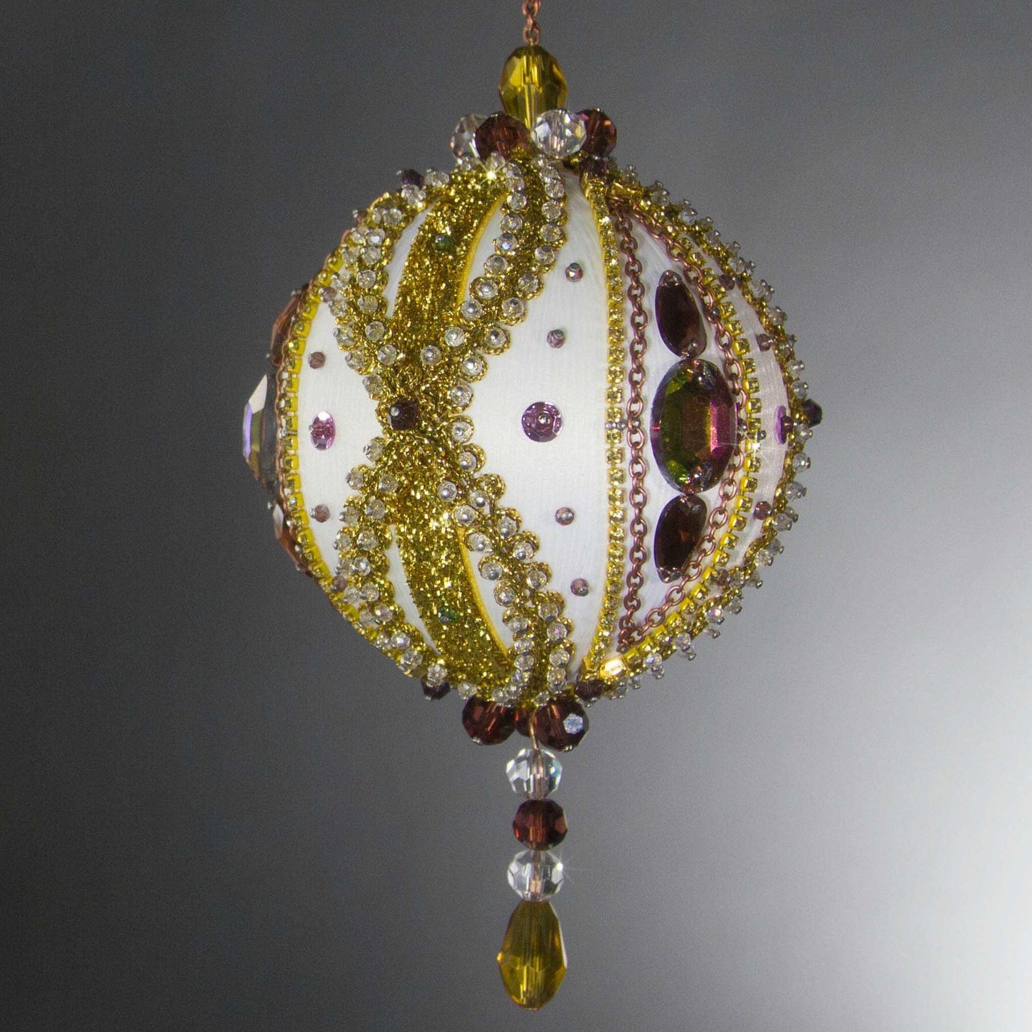 Handmade Satin Ornament by Whim5seasons embellished with glass rhinestones, gold braided trim, and crystal beads. Side view. (White).
