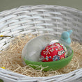 Load image into Gallery viewer, Handmade red Easter egg with floral embroidery inside a green storage container on straw with a white woven basket background. (Dark Red).