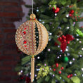 Load image into Gallery viewer, Handmade gold satin push pin ornament beaded with small pearls and red rhinestones, hanging on a chain in front of a Christmas tree.