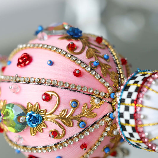 Close-up detail of handmade Christmas DIY beaded ornament Arabesque featuring rhinestone chains attached to a pink satin foam ball with dressmaker pins by Whim5seasons.