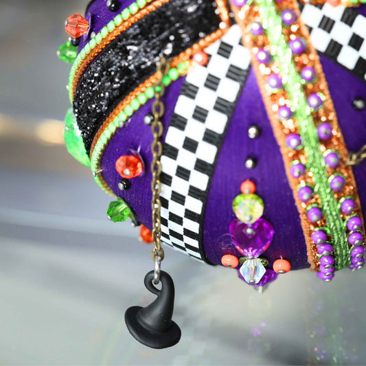 Top large bead detail of Halloween handmade ornament adorned with mini witch hat charms. (Indigo)