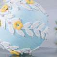 Load image into Gallery viewer, A close-up of a handmade push pin ornament's bottom with glass beads and metallic trim on a gray background. (Light Blue)