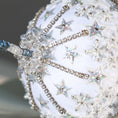 Load image into Gallery viewer, A close-up of sparkly beads and silver star-shaped sequins on a white satin foam core ball featuring a completed handmade push pin ornament. (White)
