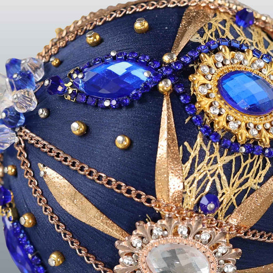 Close-up detail of a black handcrafted satin Christmas ornament with blue and clear beads pinned to the satin foam core with dressmaker pins by Whim5seasons. (Black)