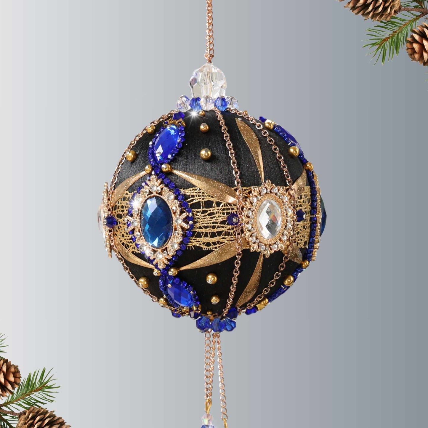 Handmade black satin ornament with crystal cameos, dark blue rhinestone chain, gold chain, hanging on a light gray background by Whim5seasons.