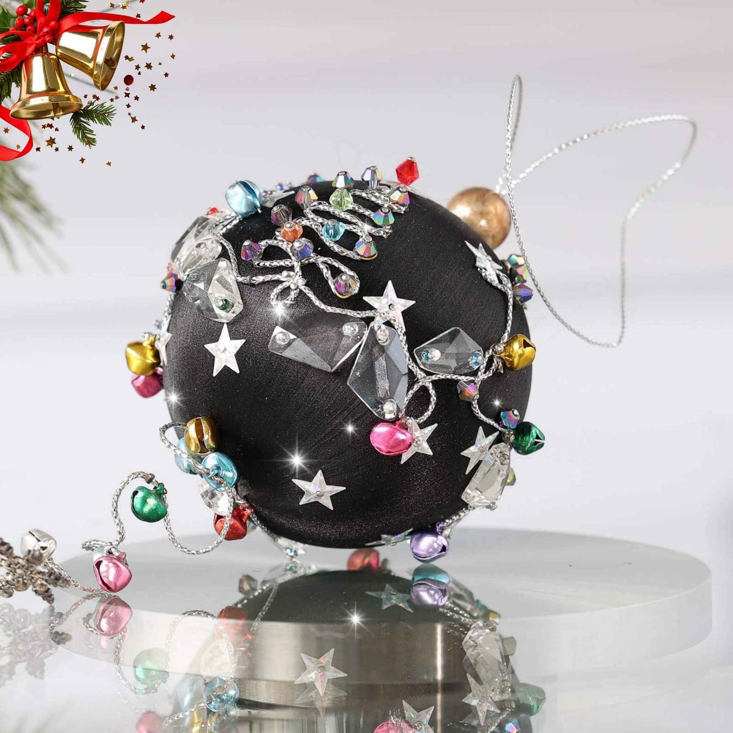 Decorative handmade black satin ornament with intricate designs on a white background on a reflective surface with a pinecone by Whim5seasons.