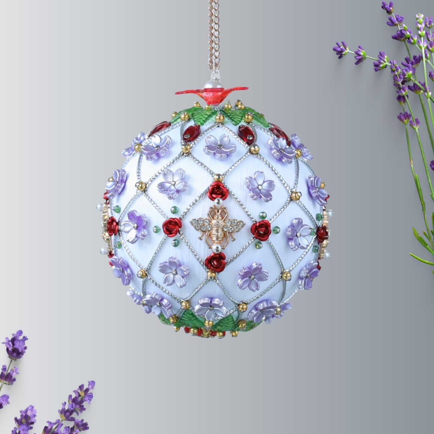 Handmade Christmas ball ornament with floral patterns, large gold bee charm, and beads on a light gray background by Whim5seasons.