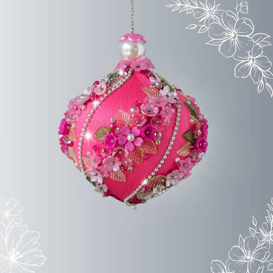Decorative pink ornament with floral details on a gray background