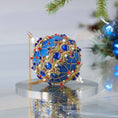 Load image into Gallery viewer, Bright blue festive handmade Christmas ornament with rhinestones, gold trim, sequins, and pearls on a reflective surface set against a light gray background with holiday greenery. (Dark Slate Blue)