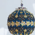 Load image into Gallery viewer, A close-up of a handmade New Year Star Ornament from Whim5seasons. It features sparkling rhinestones, and gold accents set on a rich fark blue satin ball. (Dark Slate Blue)