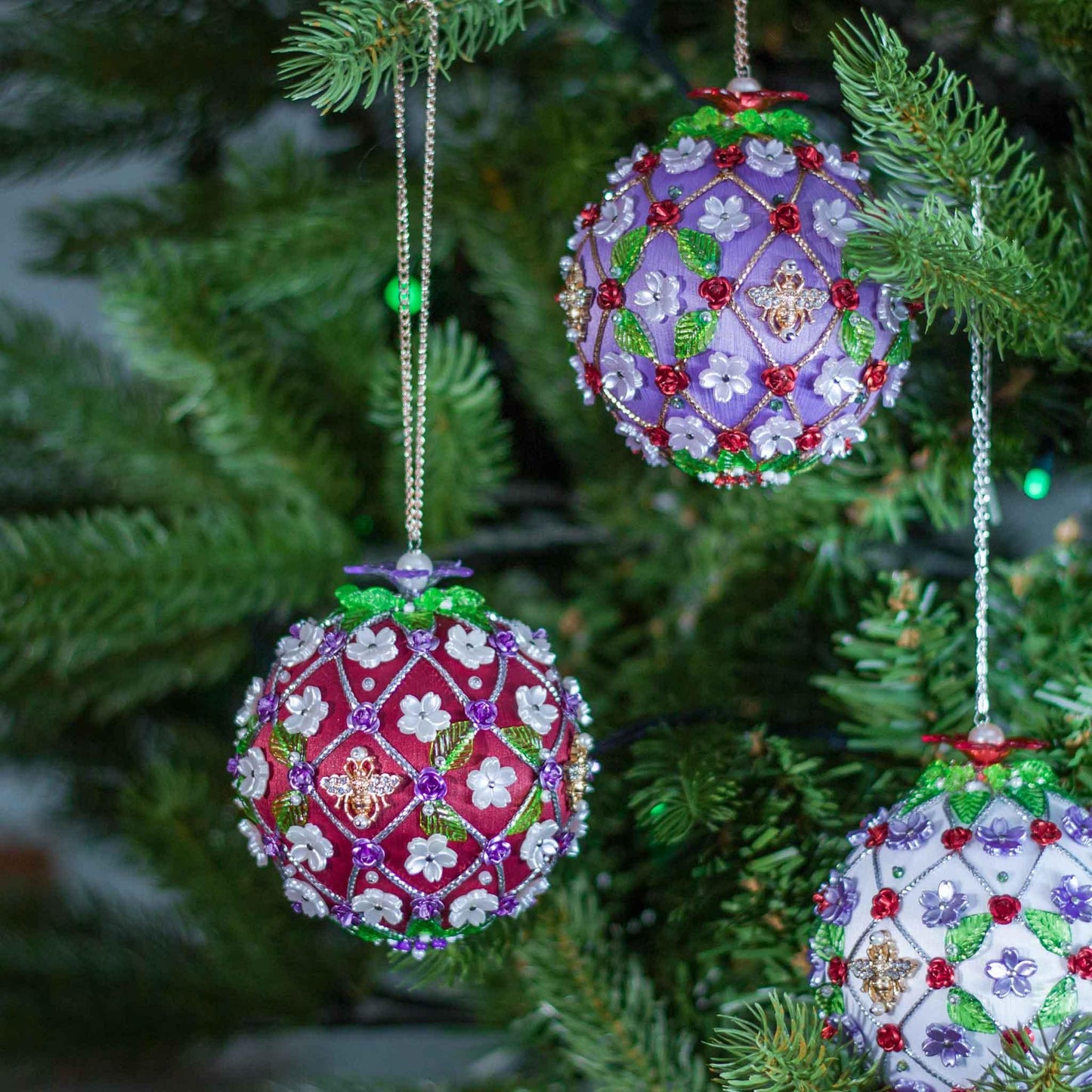 Decorative Christmas ornaments on a tree with intricate beadwork.