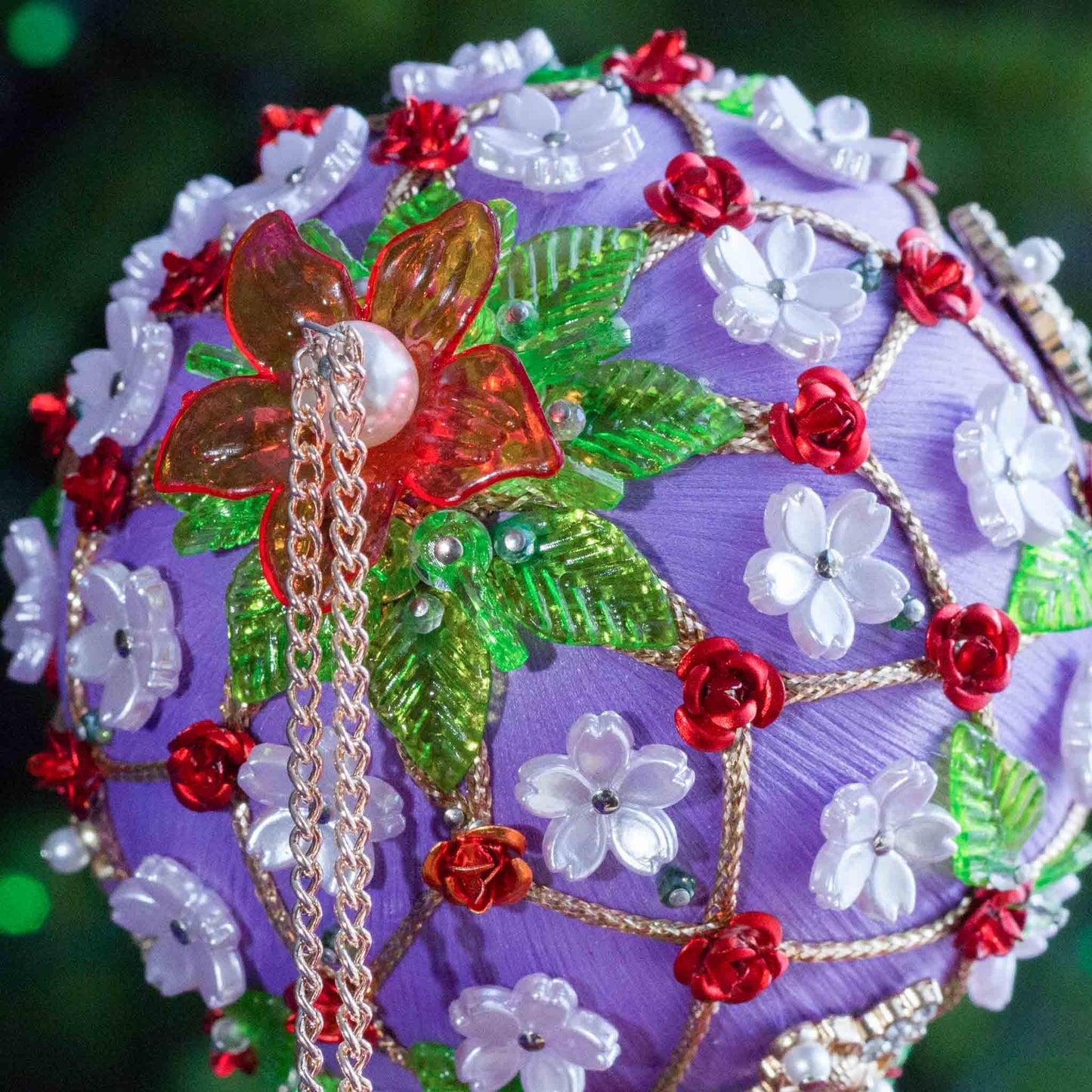 Handmade ornament with flowers, beads on a blurred green background DIY. (Medium Purple).