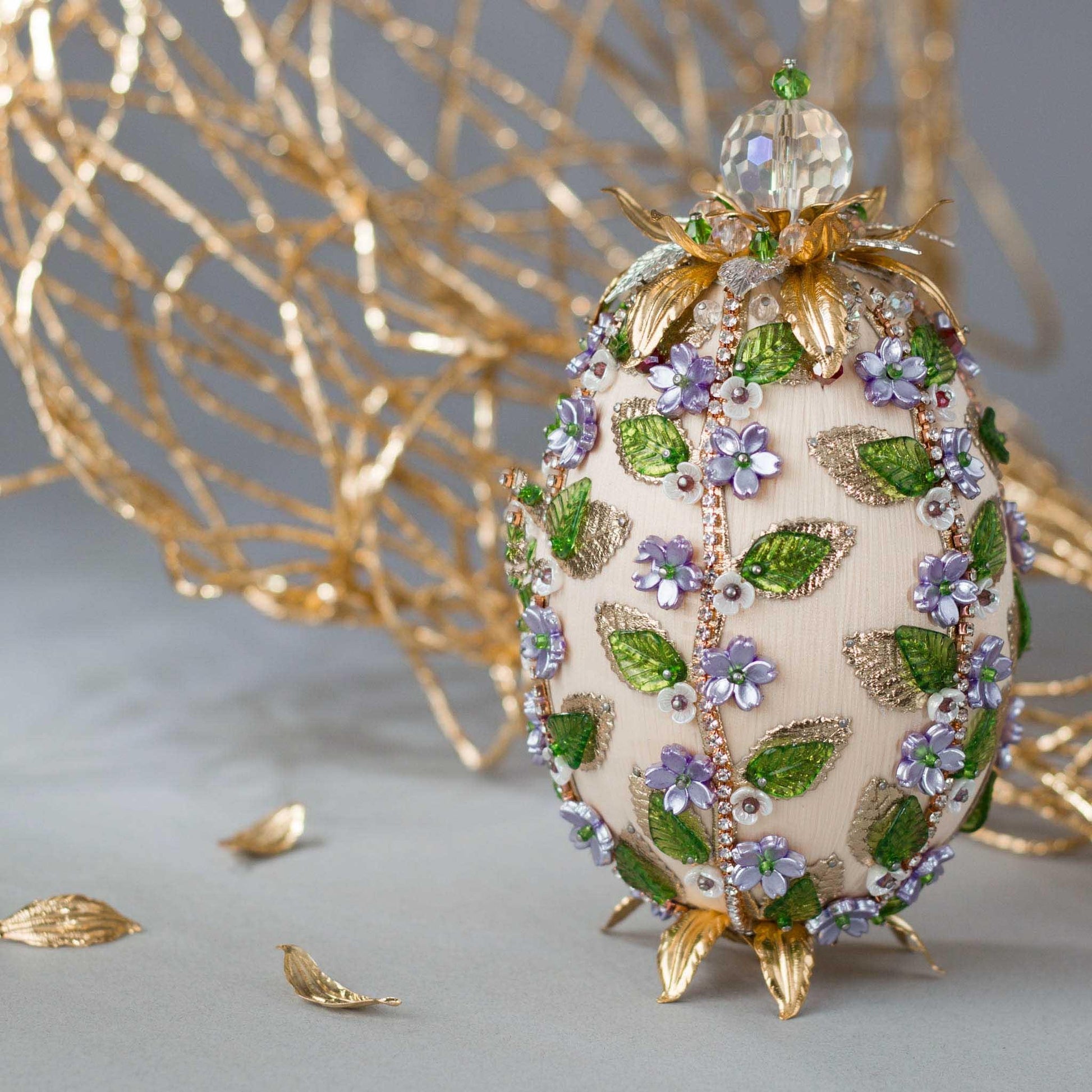 Vintage inspired charming Easter Egg Beaded Handmade Ornament embellished with flowers, leaves, gold floral trim, and crystal beads. Front. (Old Lace).