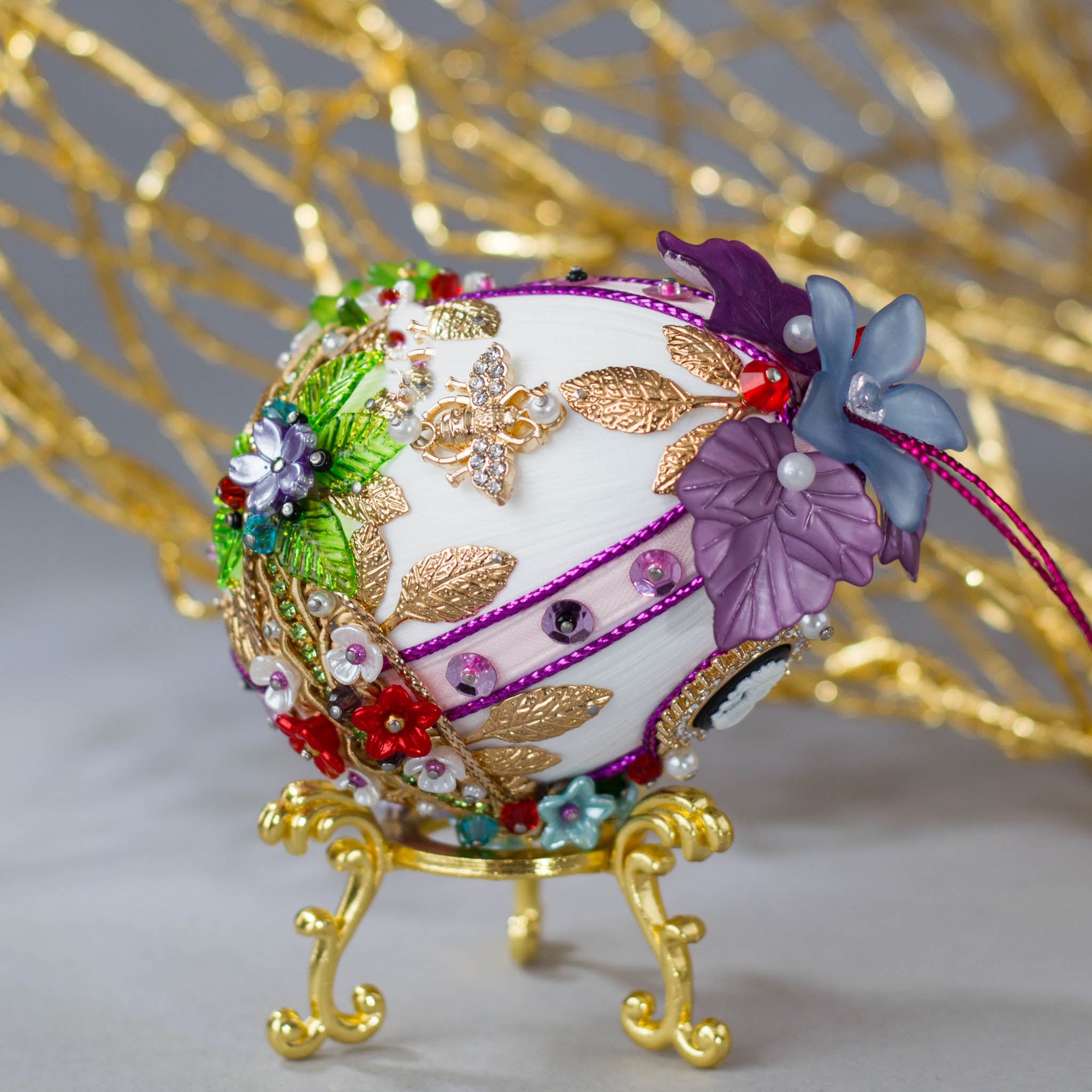 Anna Easter Egg Beaded Ornament embellished with flowers, leaves, gold floral trim, and crystal beads. Top detail. (White).