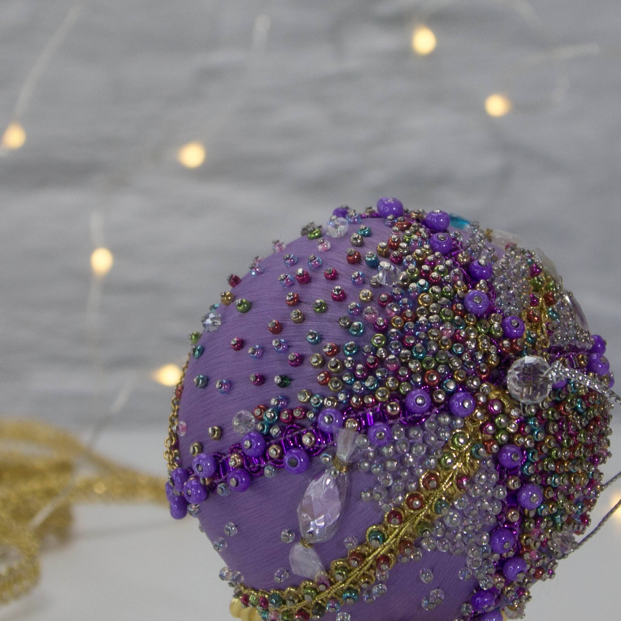 A close-up of the top of Handmade Christmas Ornament Candy by Whim5seasons - thousand of Miyuki seed beads, top crystal bead. (Medium Purple) 