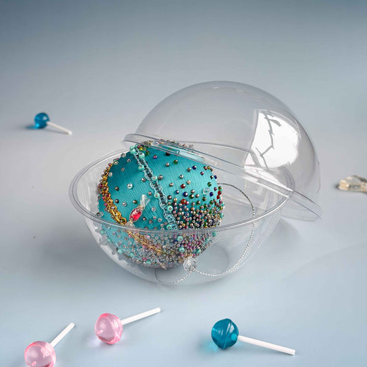 Clear plastic container with colorful beads and lollipops on a light gray . (Light Sea Green)background