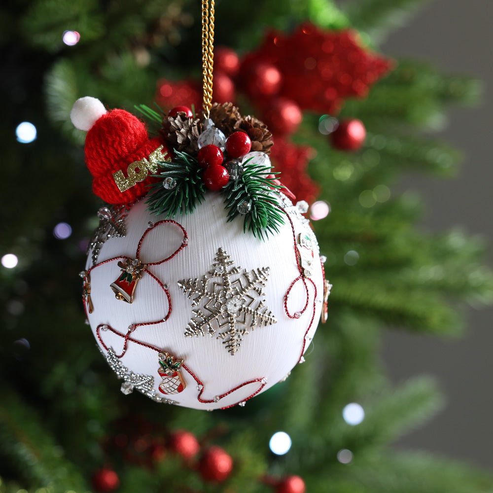 Decorative white Christmas ornament with snowflake design on a tree