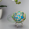 Load image into Gallery viewer, Golden Crown Easter Egg Beaded Ornament embellished with flowers, gold leaves, floral trim, and crystal beads. Bottom detail. (Sky Blue).
