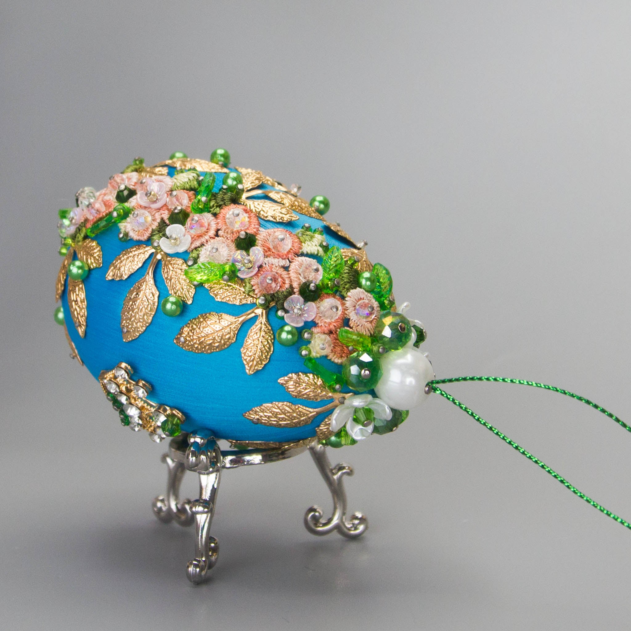 Golden Crown Easter Egg Beaded Ornament embellished with flowers, gold leaves, floral trim, and crystal beads. Top detail. (Sky Blue).