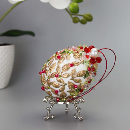 Golden Crown Easter Egg Beaded Ornament embellished with flowers, gold leaves, floral trim, and crystal beads. Top detail. (White).