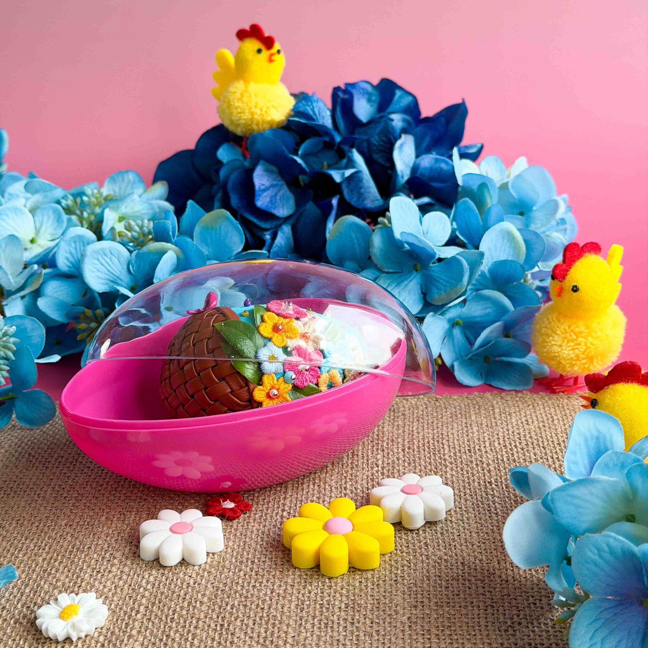 Blue push pin Easter egg  with flowers, and chicks on a pink background with blue flowers. (Sky Blue)
