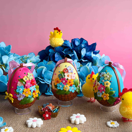 Handmade Easter eggs decorations with chicks and flowers on a pink background.