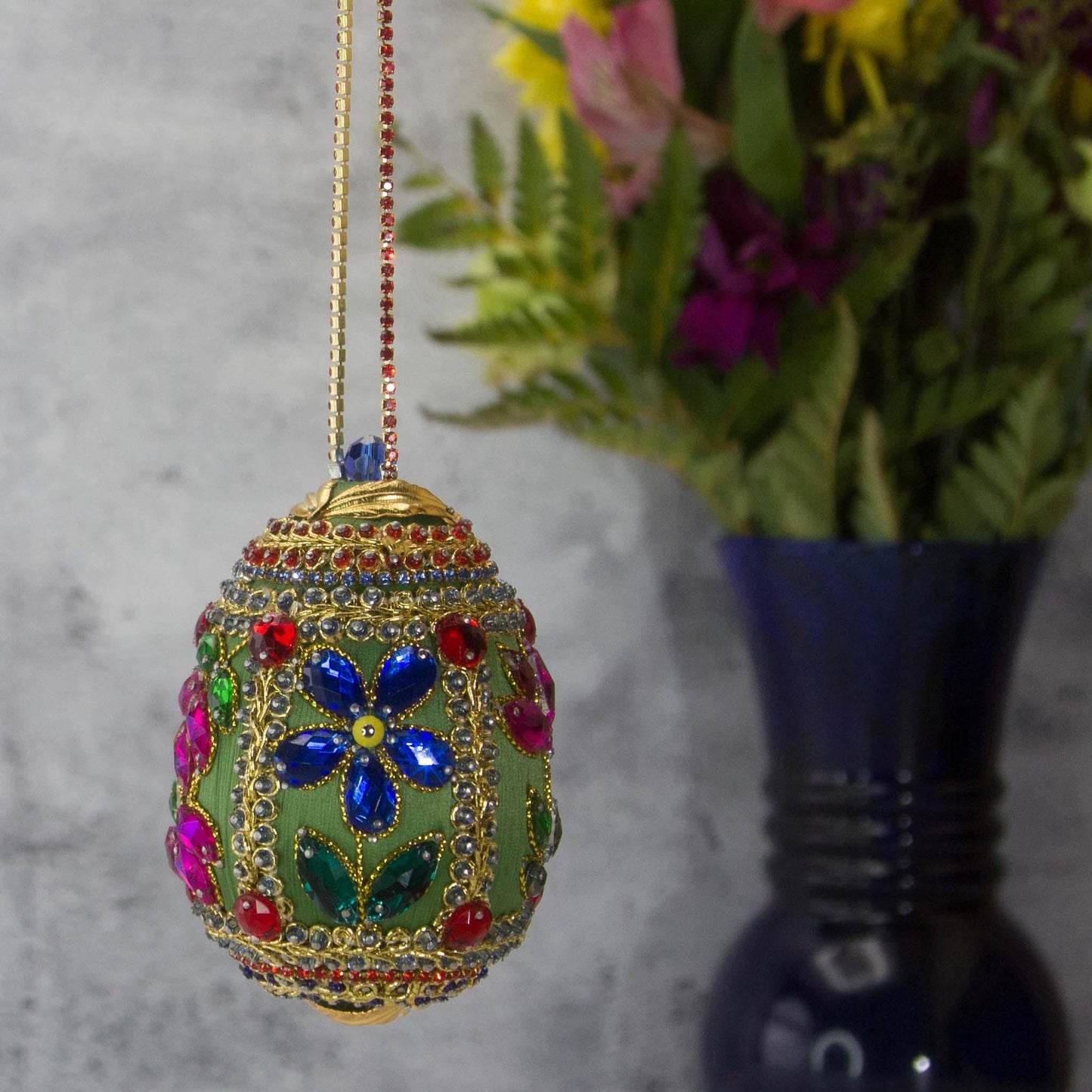 Handmade Easter Egg Beaded Ornament embellished with flowers, leaves, gold floral trim, and crystal beads. Side. (Olive).