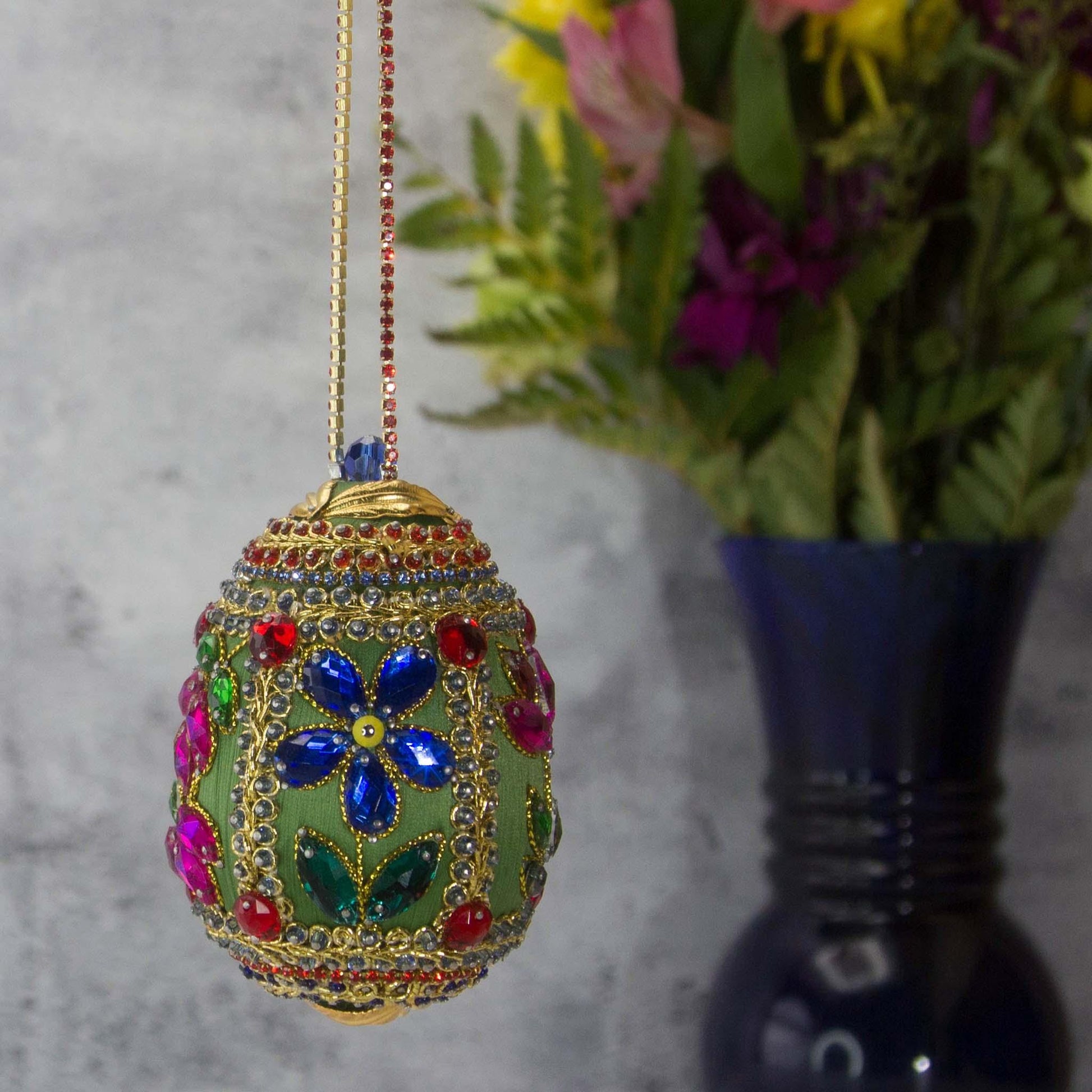 Handmade Easter Egg Beaded Ornament embellished with flowers, leaves, gold floral trim, and crystal beads. Side. (Olive).