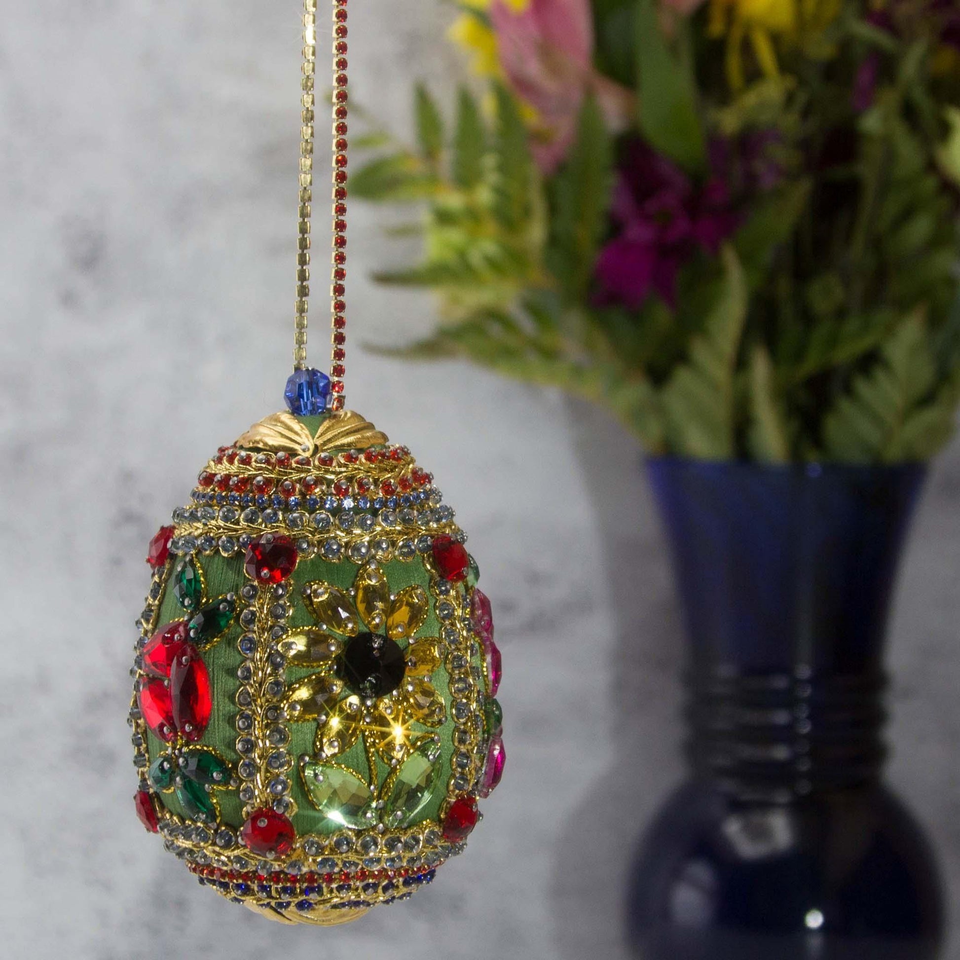 Handmade Easter Egg Beaded Ornament embellished with flowers, leaves, gold floral trim, and crystal beads. Side1. (Olive).