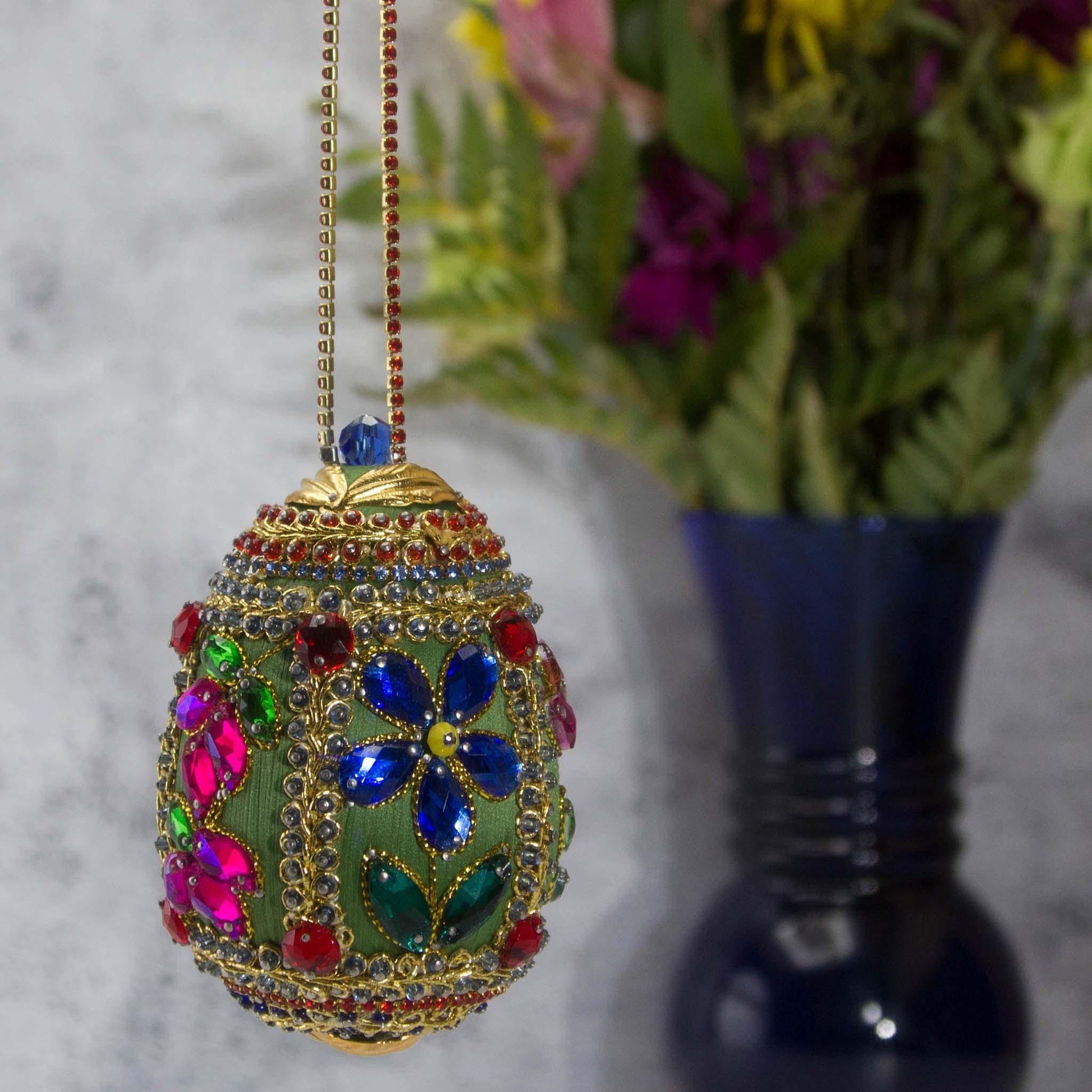 Handmade Easter Egg Beaded Ornament embellished with flowers, leaves, gold floral trim, and crystal beads. Side. (Olive).