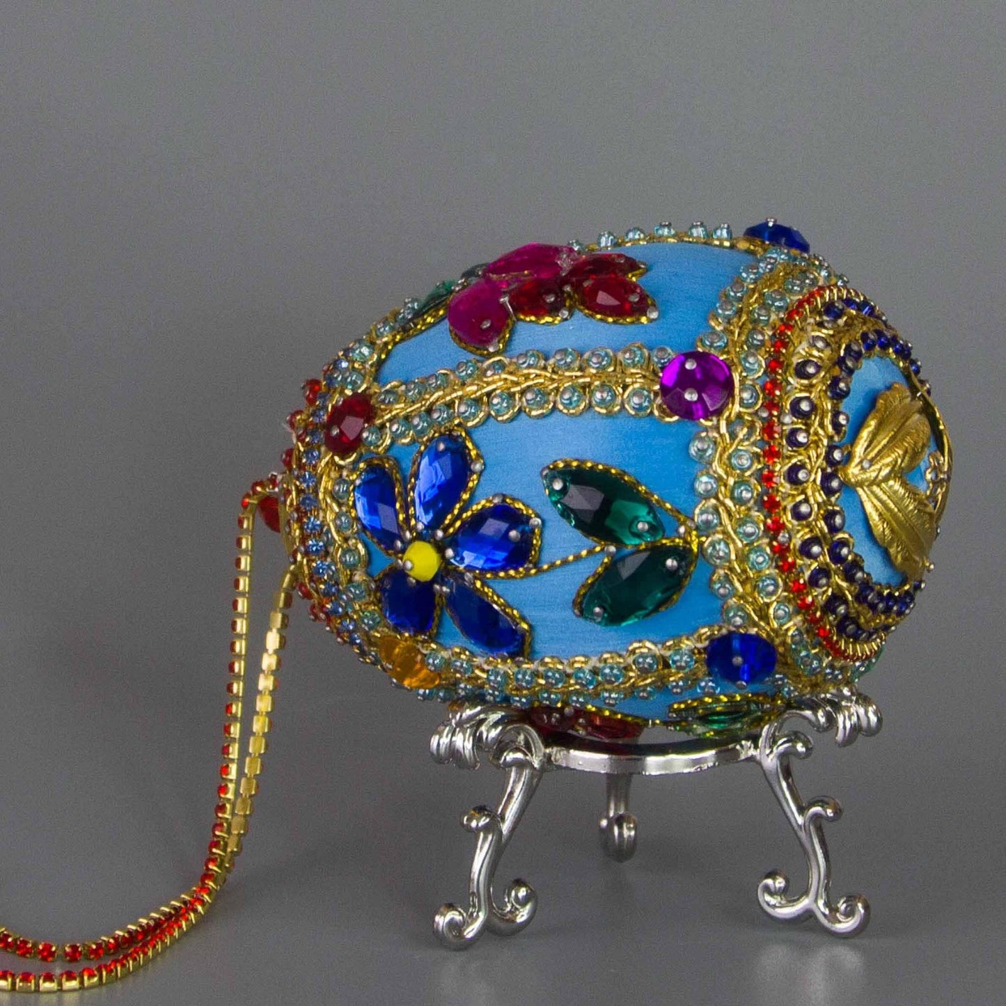 Handmade Easter Egg Beaded Ornament embellished with flowers, leaves, gold floral trim, and crystal beads. Bottom detail. (Sky Blue).