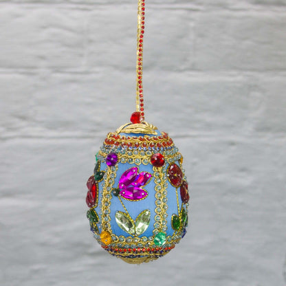 Handmade Easter Egg Beaded Ornament embellished with flowers, leaves, gold floral trim, and crystal beads. Side. (Sky Blue).