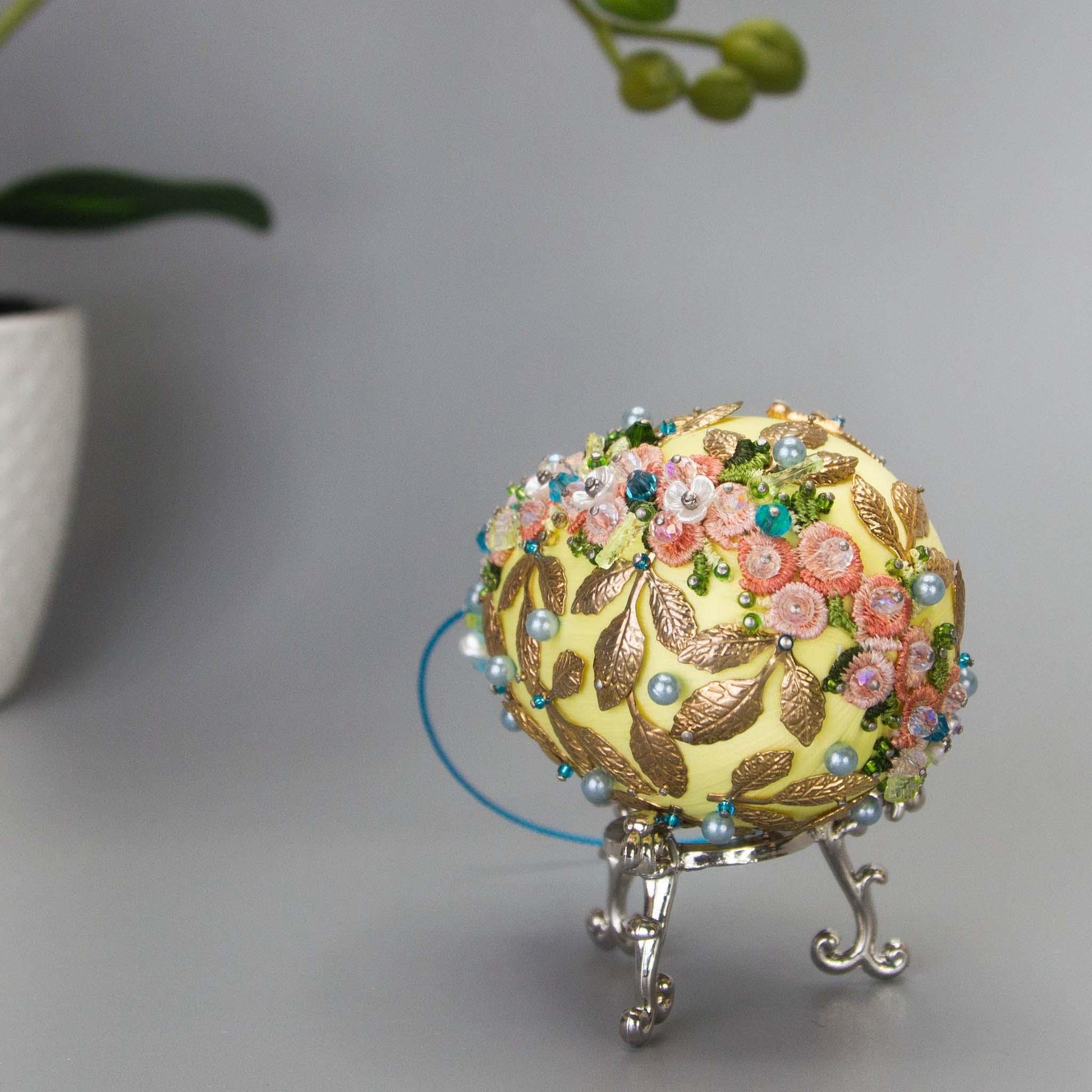 Golden Crown Easter Egg Beaded Ornament embellished with flowers, gold leaves, floral trim, and crystal beads. Bottom detail. (Light Yellow).