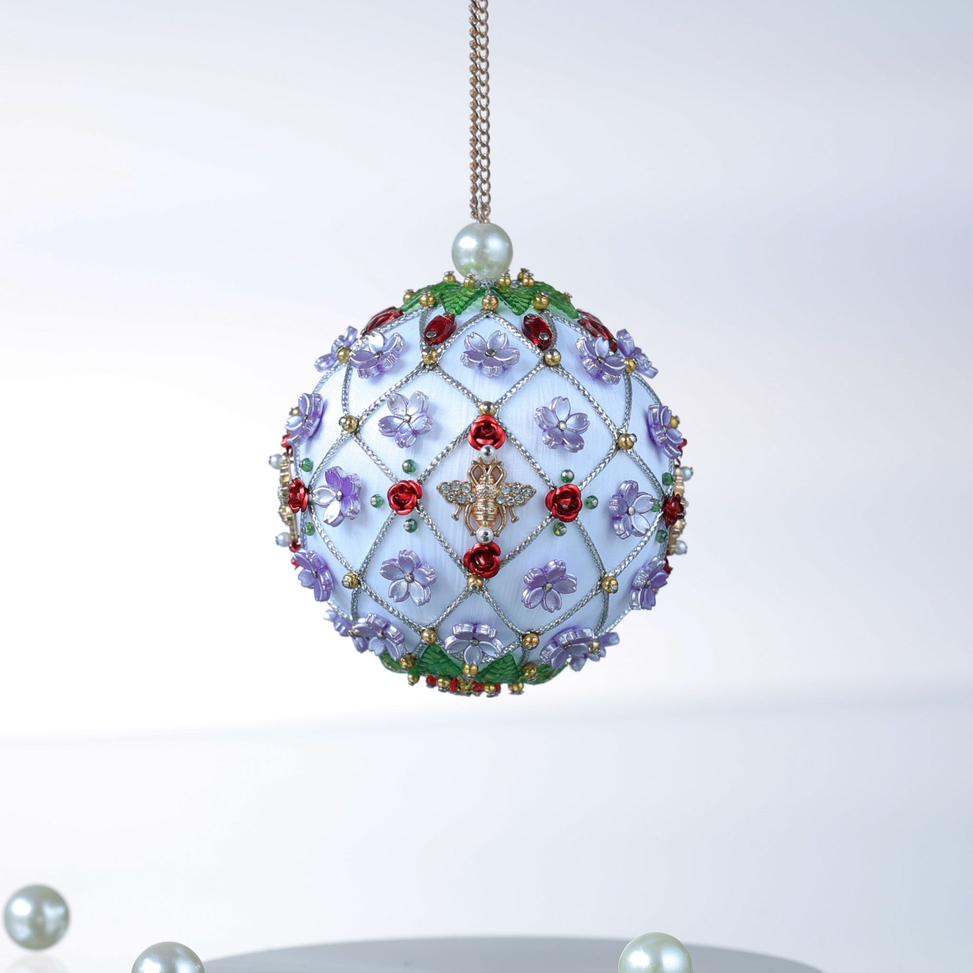Handmade Christmas ball ornament with floral patterns, large gold bee charm, and beads on a light gray background by Whim5seasons.